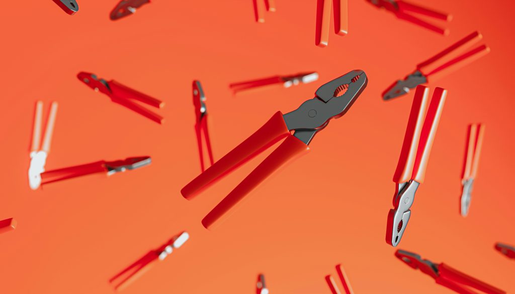 Red-handled pliers floating against a vivid orange backdrop, a visual nod to SAS's framing of AI as just one tool among many in the enterprise toolkit.