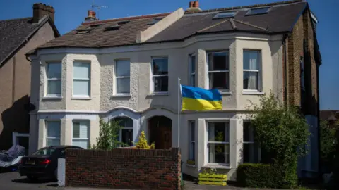 Getty Images A semidetached victorian house. In the front garden a yellow and blue ukrainian flag has been erected. A window box has also been painted yellow.