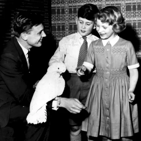 PA Media Image from 1958 in black and white of Prince Charles with his sister Princess Anne meeting David Attenborough and Cocky, the cockatoo